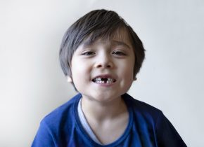 6-7 year old boy smiling and showing his missing teeth. Cute Chi